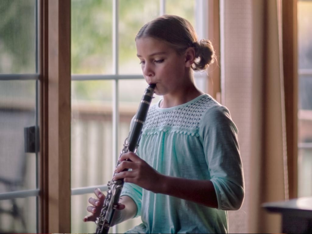 Child practicing clarinet with teacher